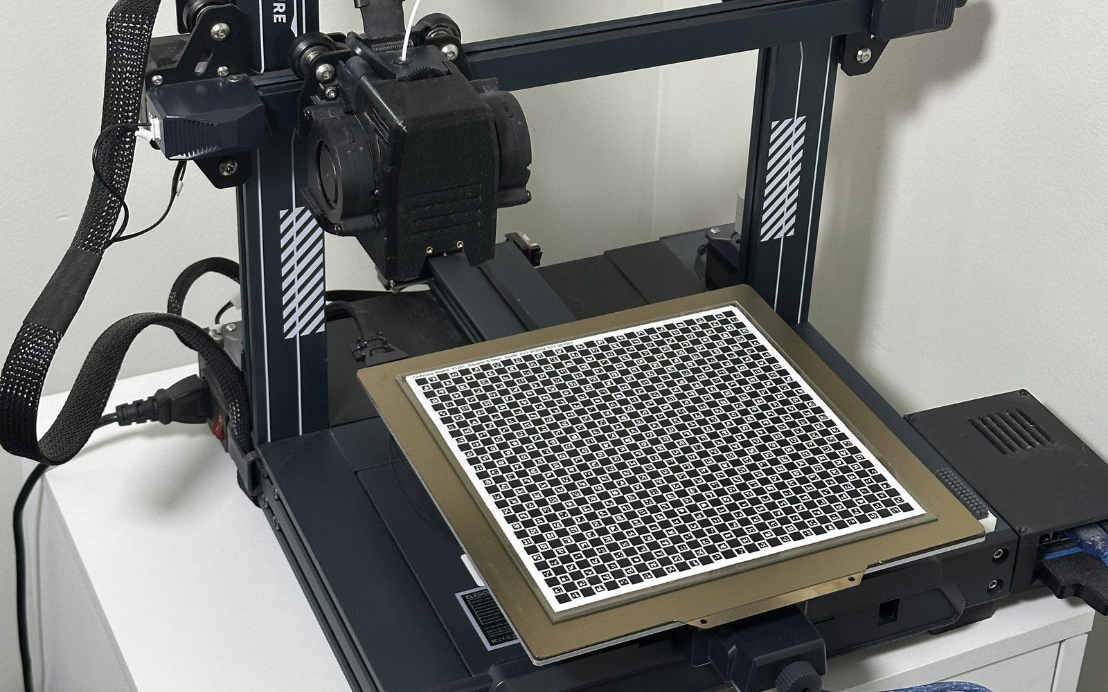 3D printer with a ChArUco calibration board on the bed